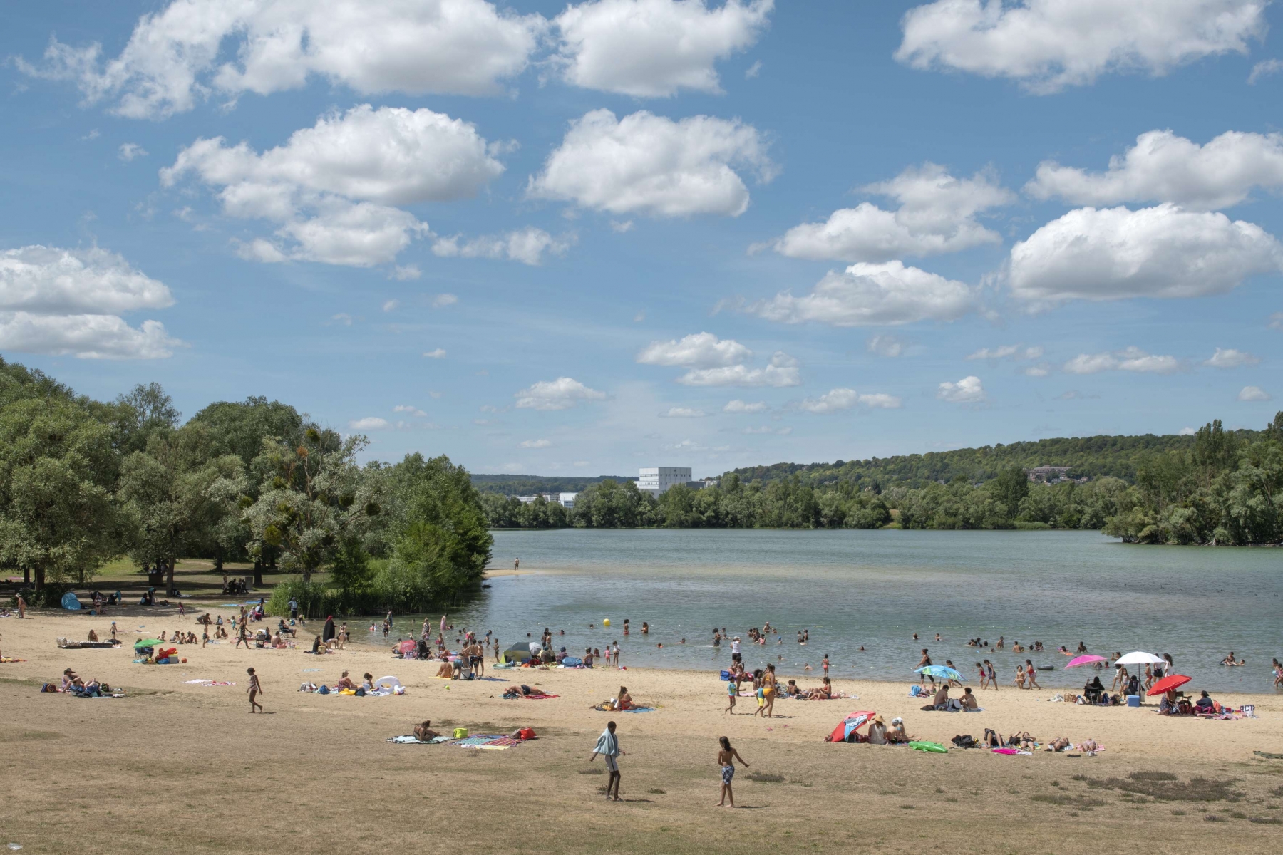 Usagers au bord d’un plan d’eau dans un paysage boisé